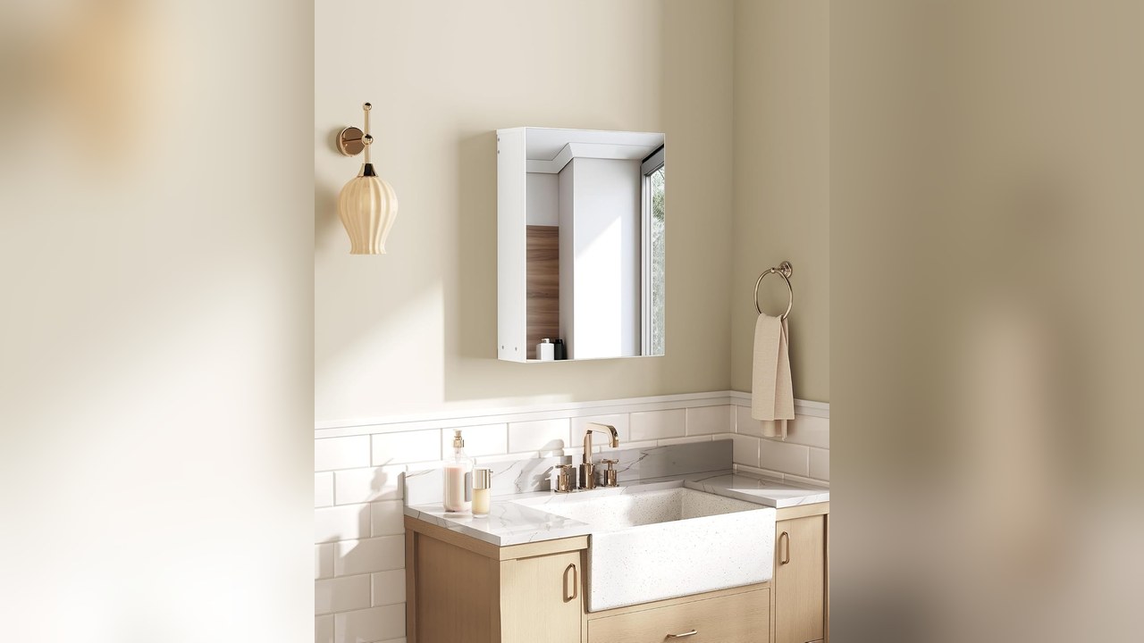 White wall mounted bathroom medicine cabinet with a mirrored door above a vanity sink