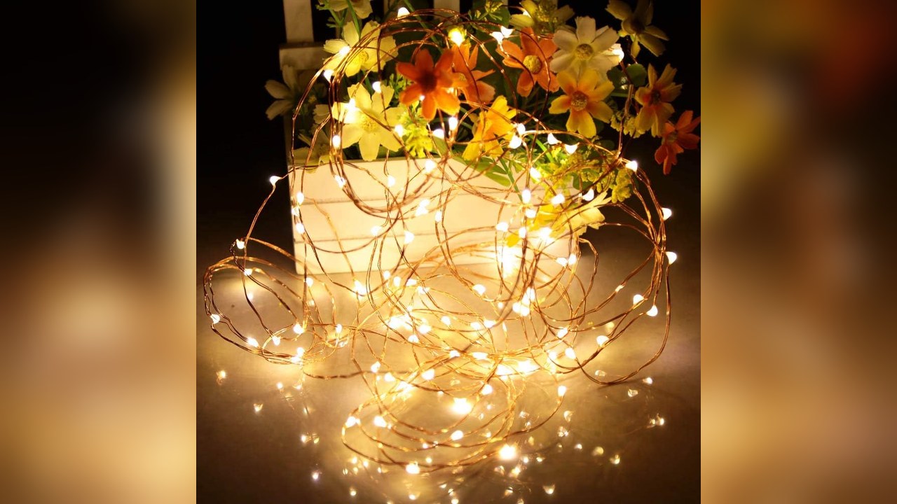 Warm white copper wire fairy lights glowing around ornaments