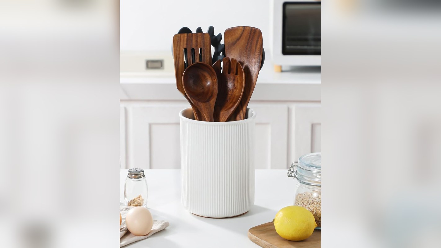 White ceramic utensil crock with spatulas next to a stove