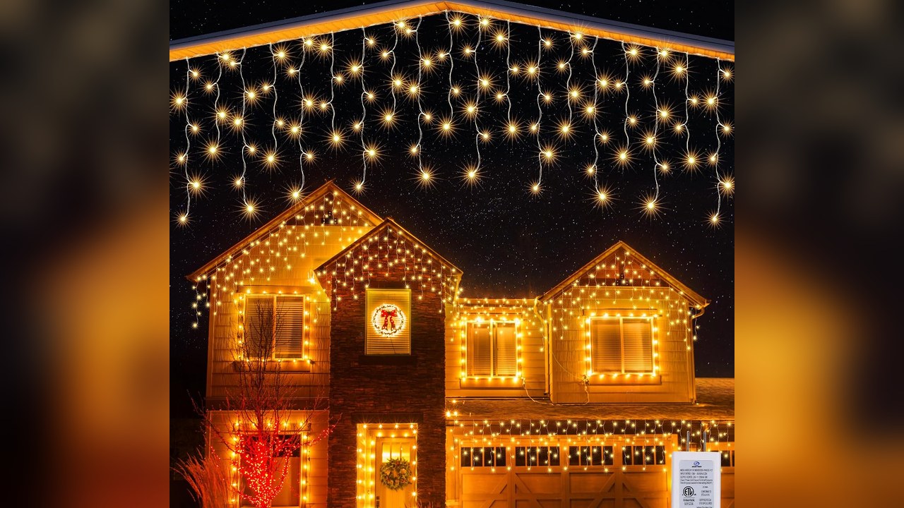 Warm white icicle lights hanging along a house gutter