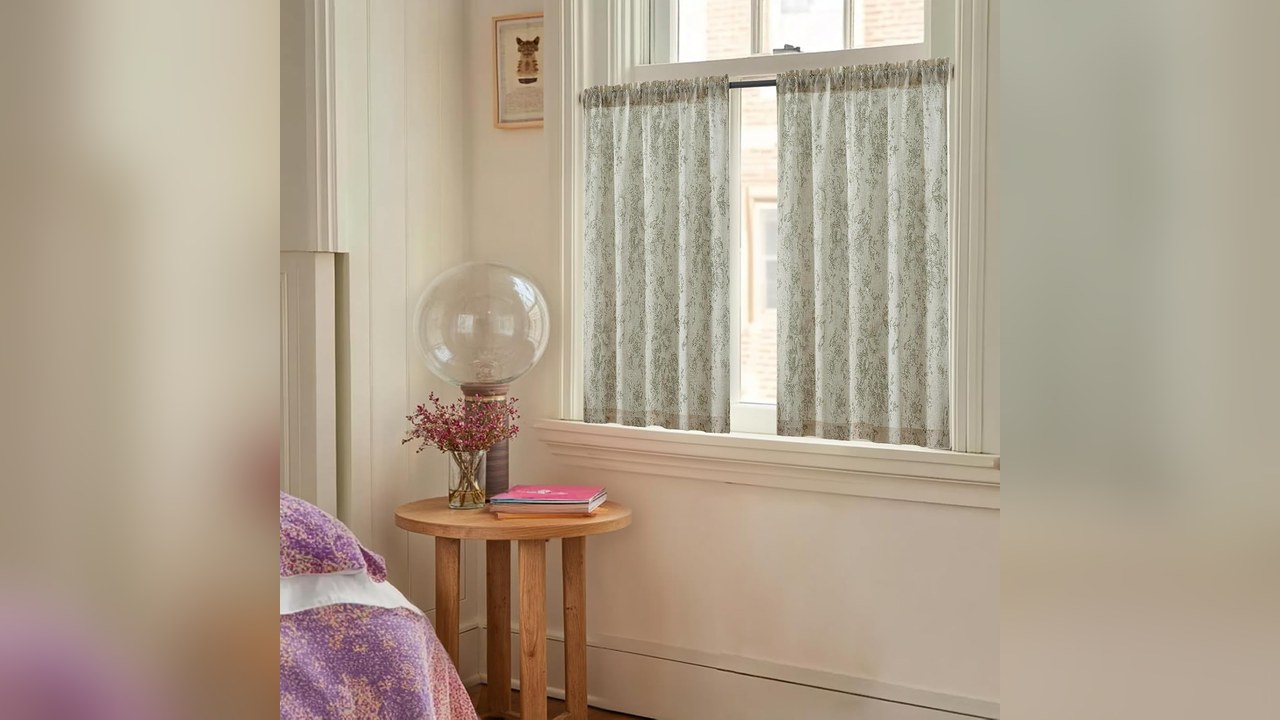 Sage floral cafe curtains covering the lower half of a kitchen sink window