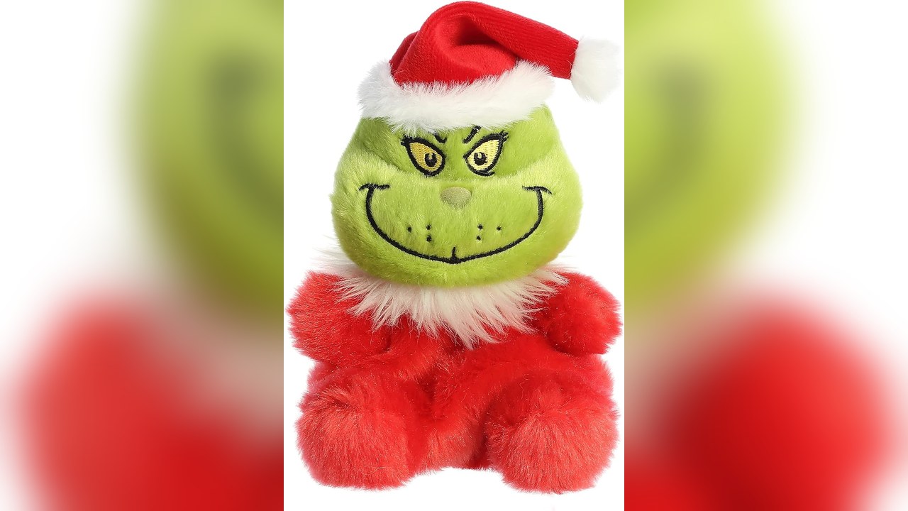 Grinch plush in Santa hat on a shelf