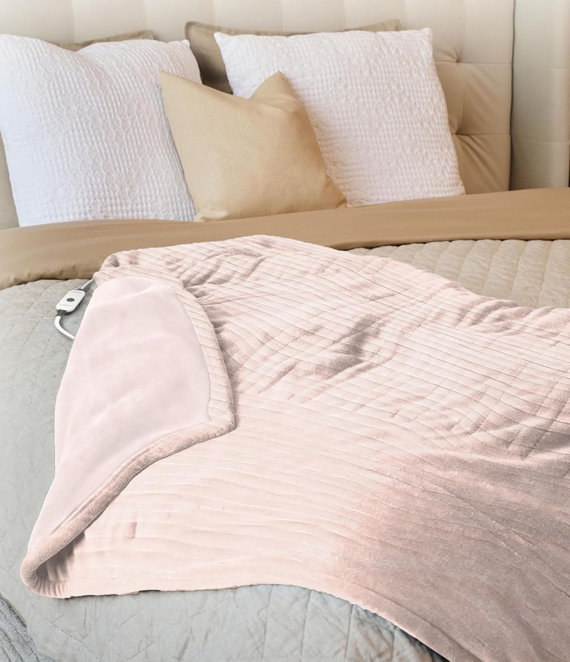 Heated throw blanket spread across the foot of a bed