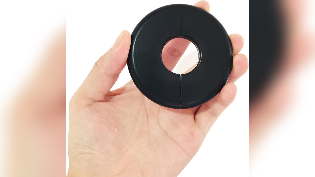 Hand holding a black round self-adhesive wall split flange ring cover