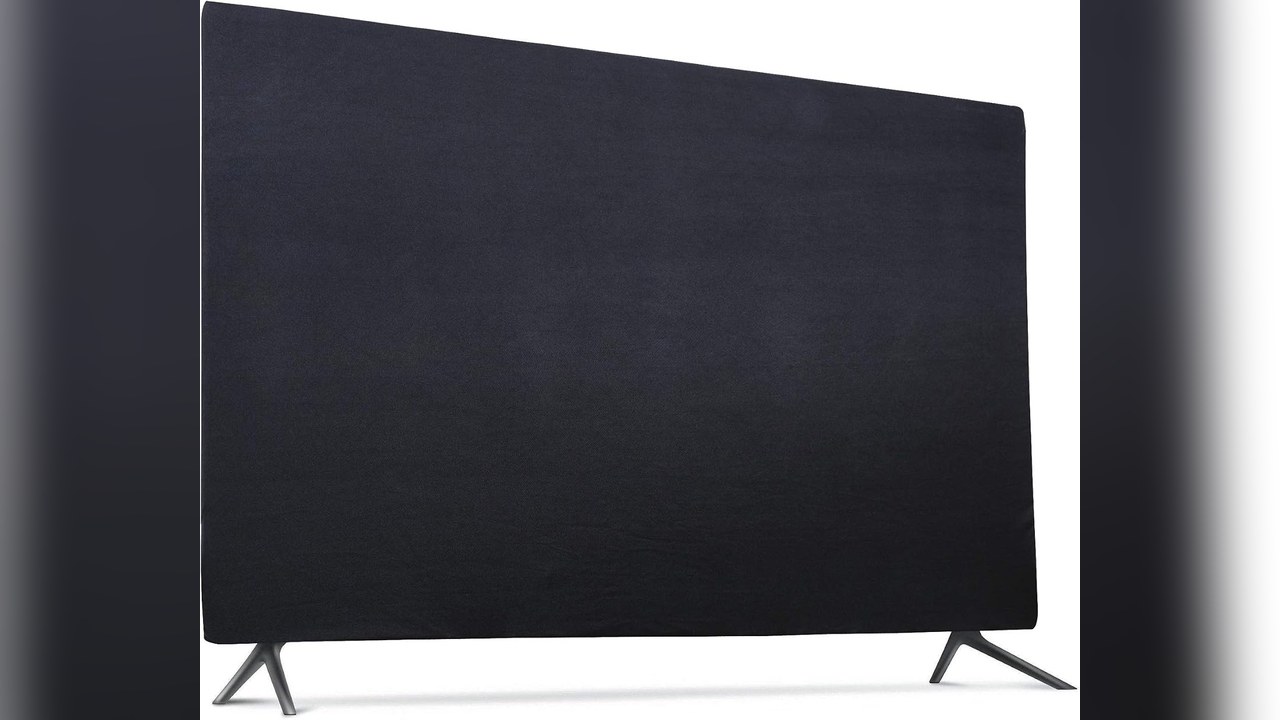 Black stretch fabric cover over a wall-mounted TV above a wood console