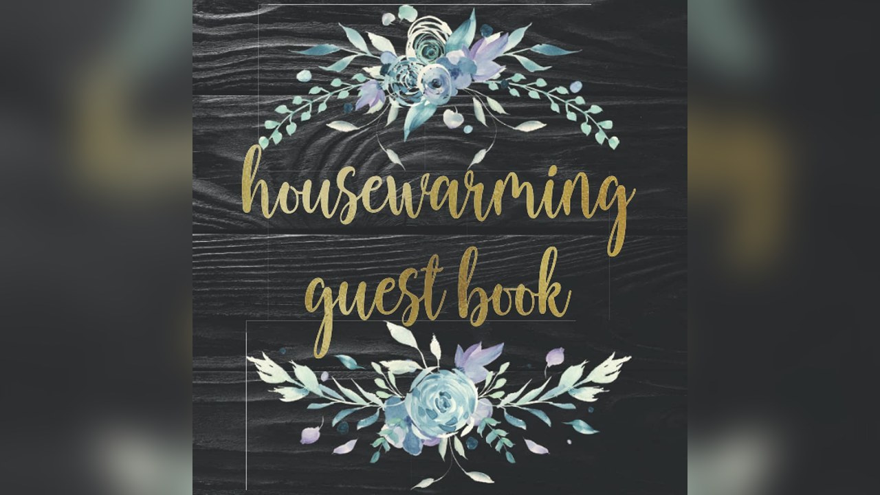 Housewarming guest book open on a shelf with a pen