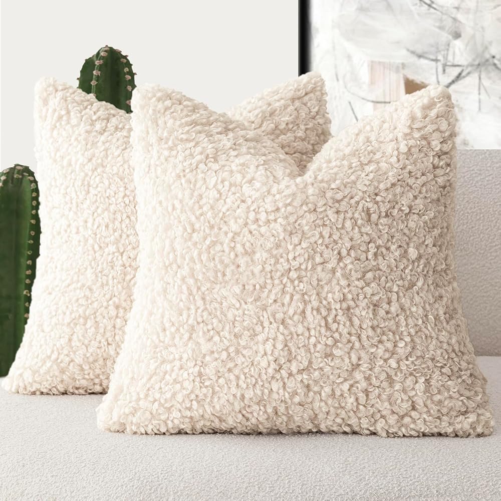Cream faux fur pillow covers on a bed