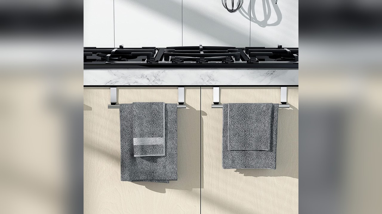 Stainless steel over cabinet towel bar holding a dish towel