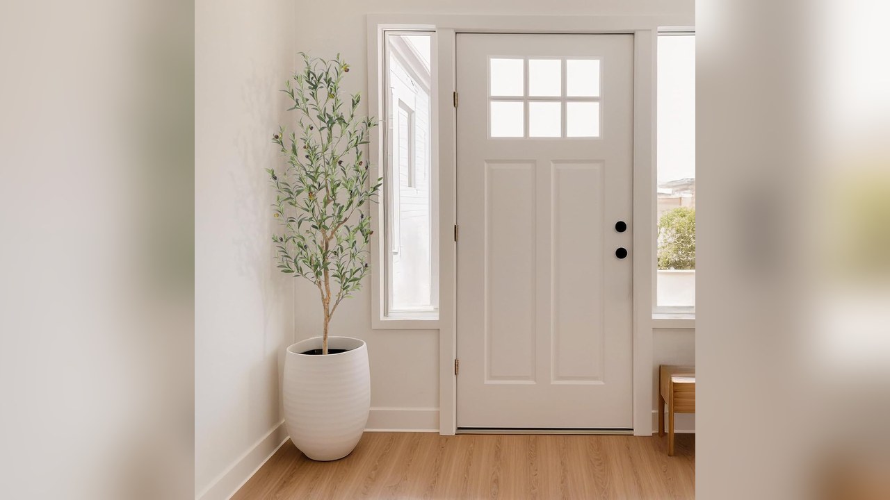 Tall faux olive tree in a living room corner