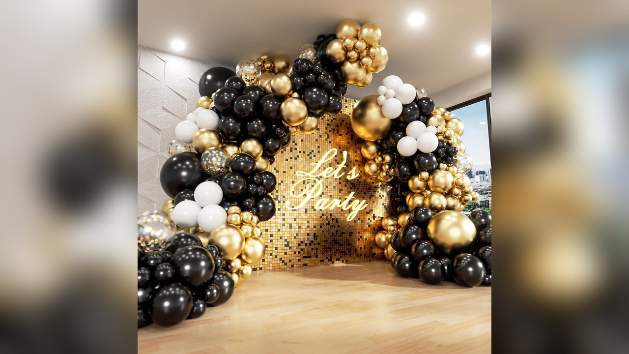 Black, white and gold balloon arch framing a hallway for new years eve