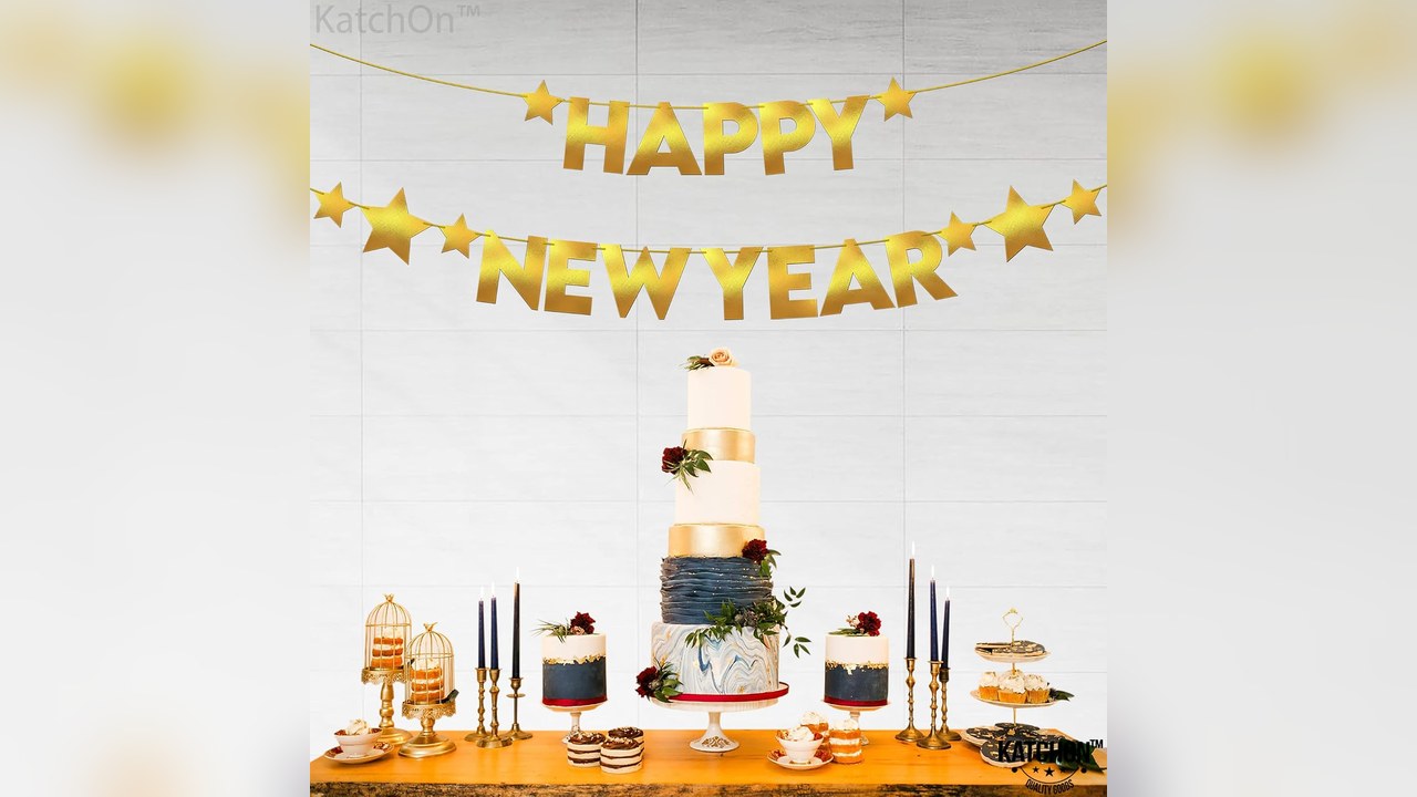 Gold glitter happy new year banner hanging over a dessert table