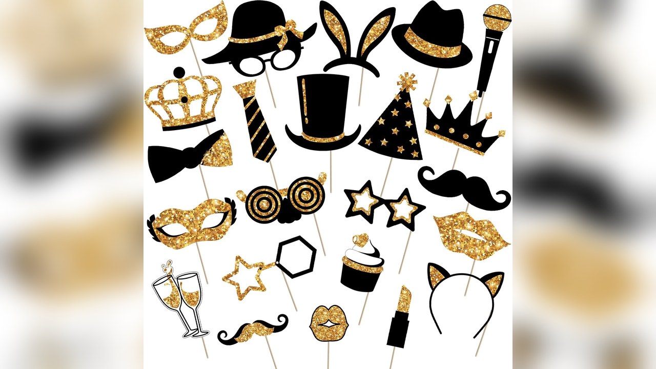 Black and gold new years photo booth props in a jar next to a backdrop