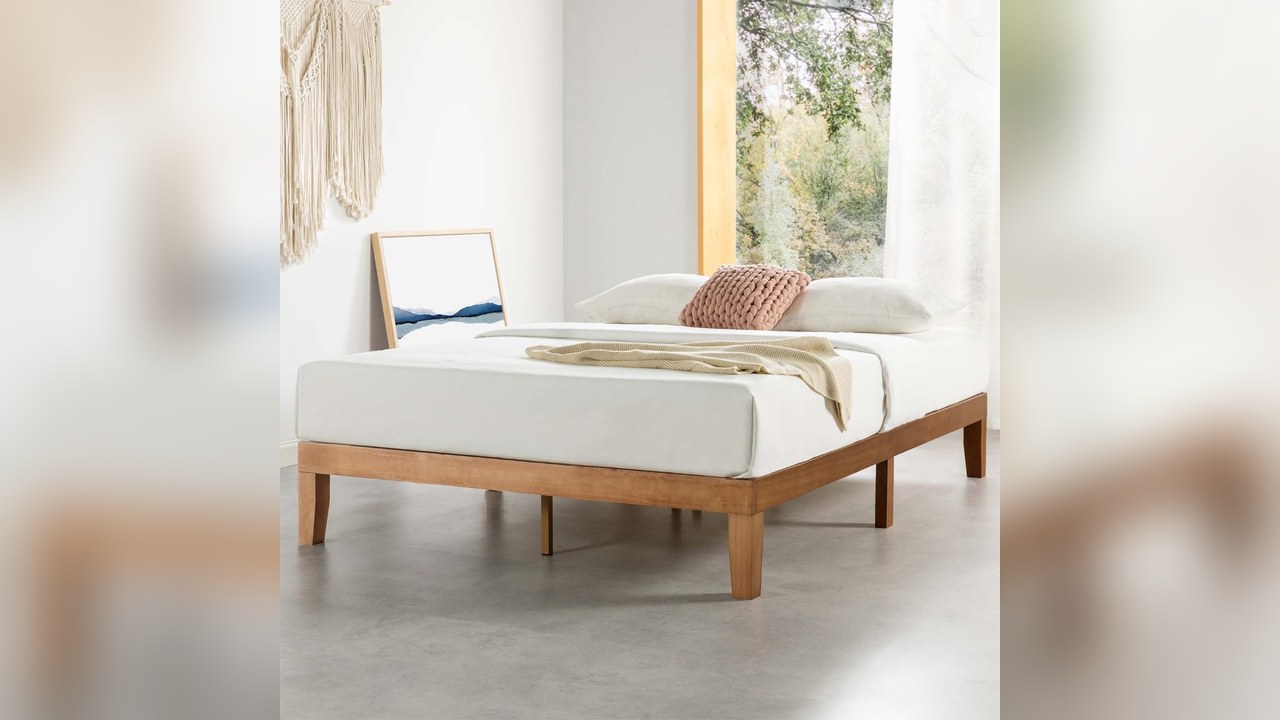 Mellow Naturalista solid wood platform bed frame with white bedding in a bedroom with large window