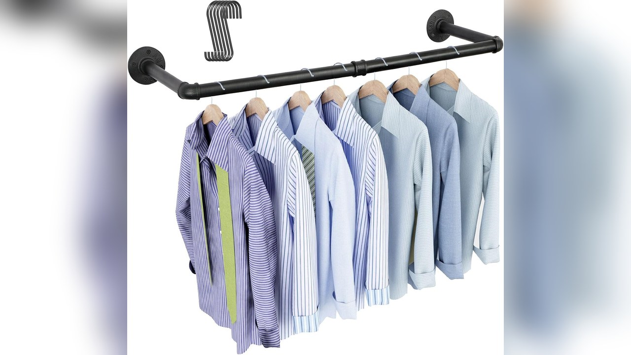 OROPY black industrial pipe clothing rack mounted on a bedroom wall with shirts and blouses hanging
