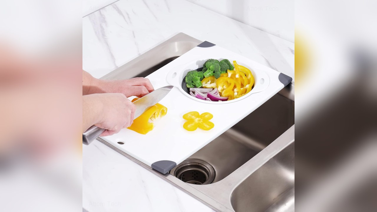 NiHome white over sink cutting board with gray collapsible colander resting across a stainless steel sink