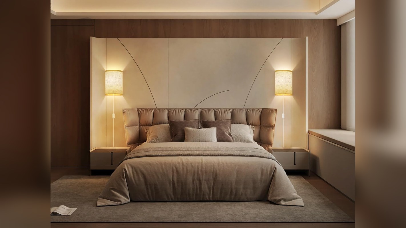 Two plug-in wall sconces glowing on either side of a bed