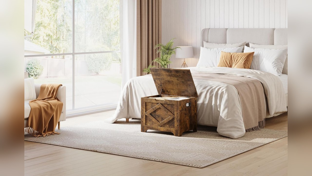 Vintage style wooden storage chest at the foot of a bed
