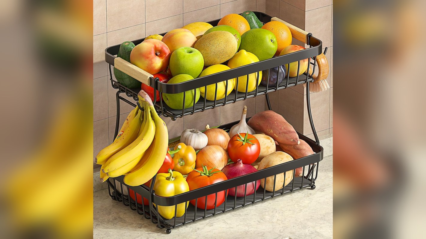 Two tier fruit basket with bananas hanging on hooks in a kitchen