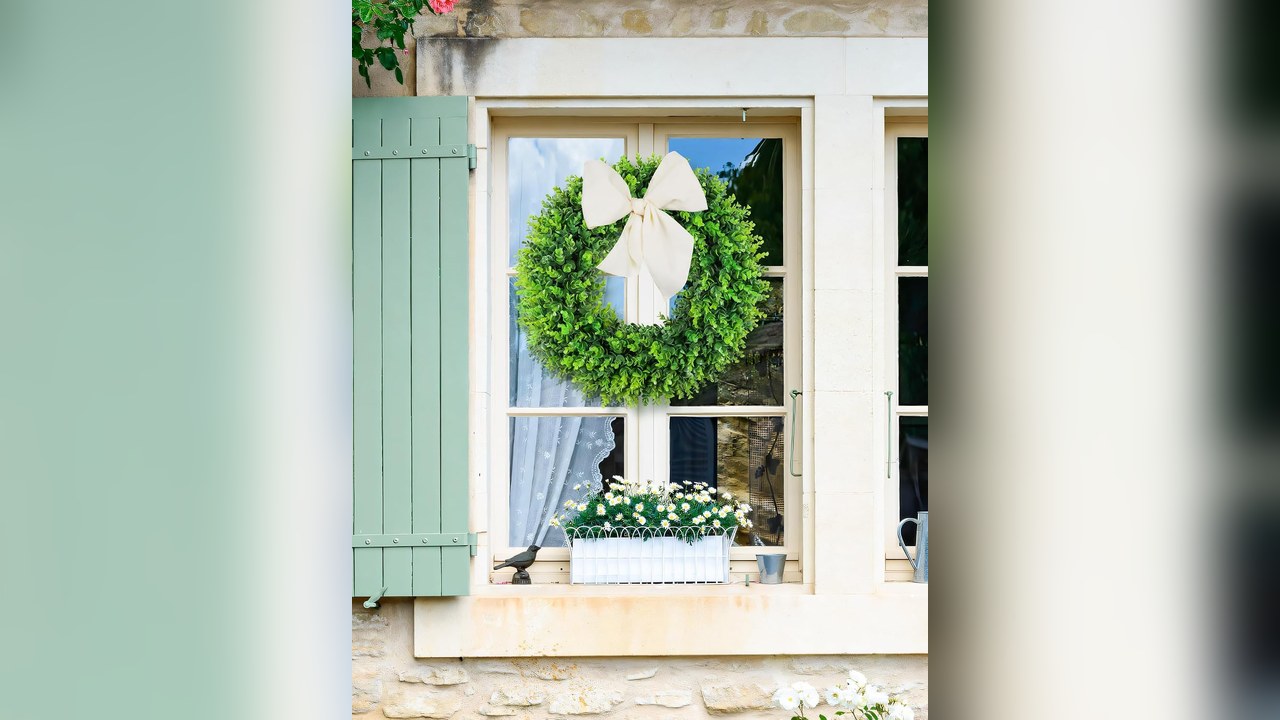 Round boxwood wreath on a white front door
